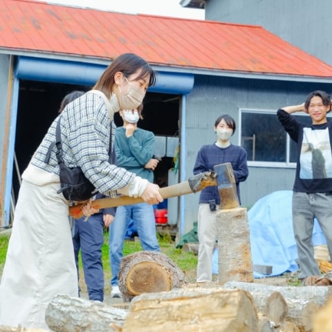 厚真神社で行われていたお祭りのなかで、参加者が斧を持って薪を割っている様子が写っています。