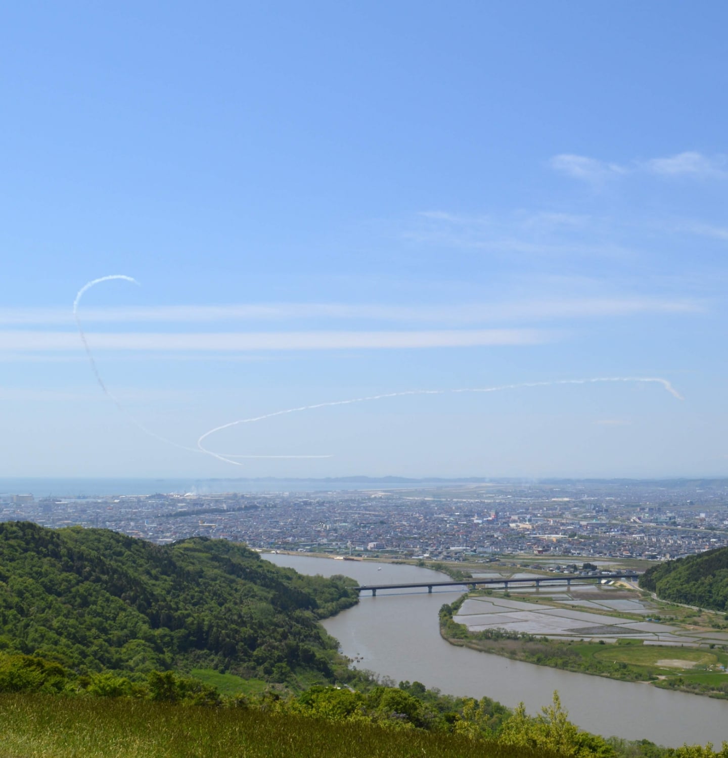migakiba ishinomakiのイメージ画像。石巻の曽波神大橋を中心に、流れる川と遠景に町並みが写っています。