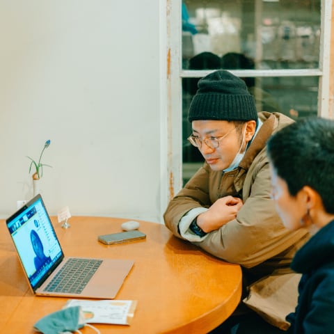 写真：migakiba uedaで実施したオンラインフィールドツアーの様子。パソコンの画面には現地事務局である株式会社バリューブックスの取締役、鳥居希さんが話している様子がうつっています。