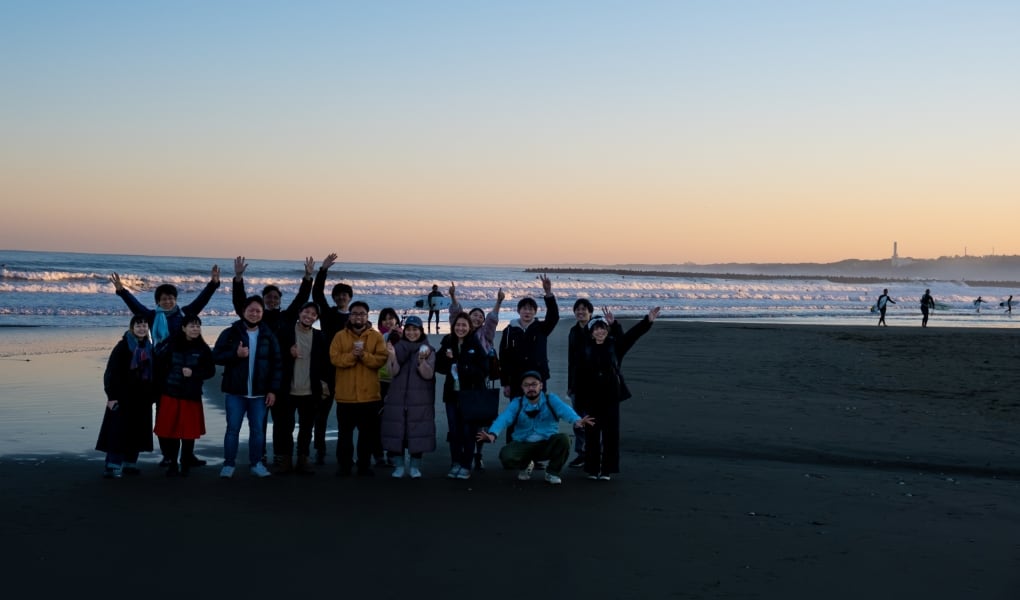 夕方時、大洗の美しい海を背景にフィールドワークに参加したメンバー16名が前後２列で写っている。
