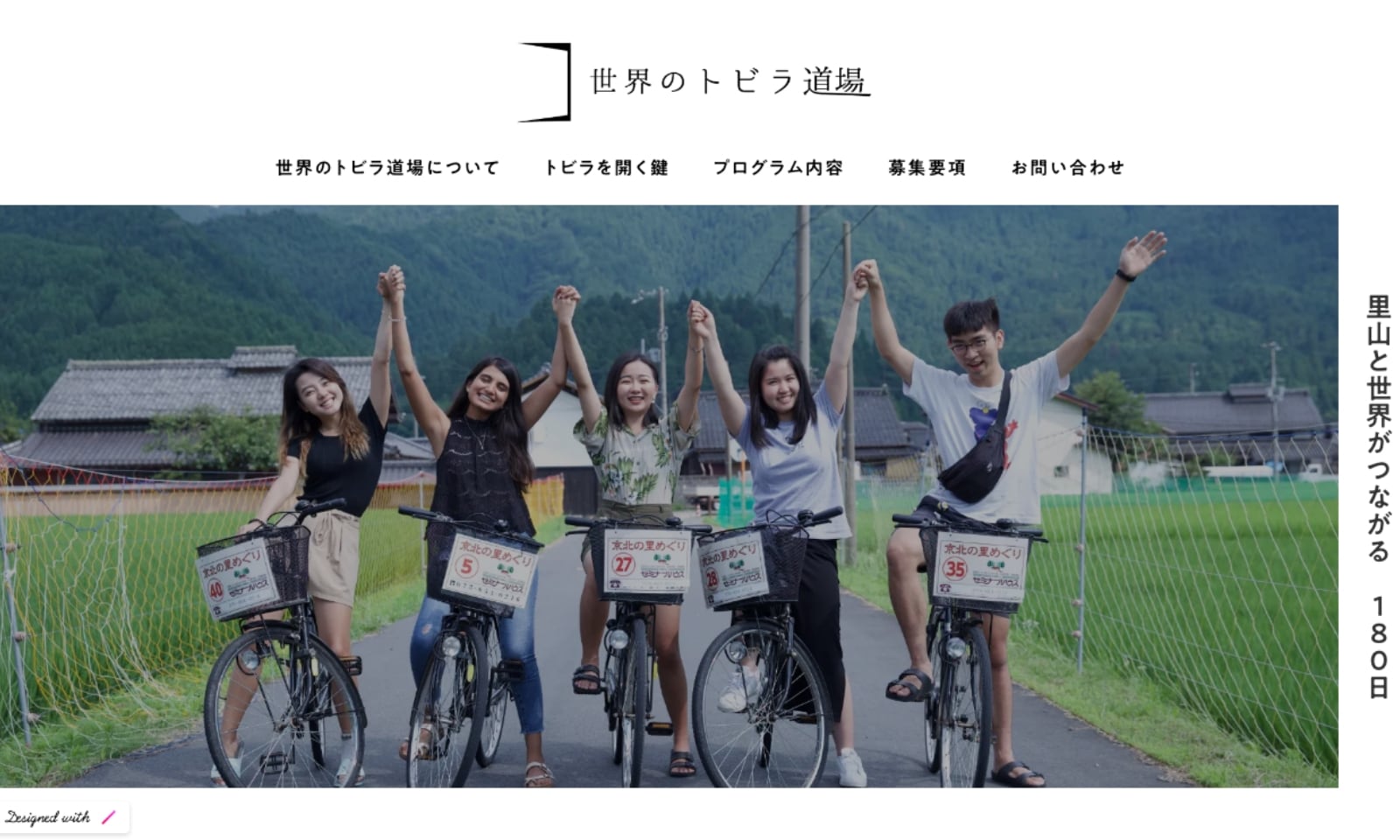 世界のトビラ道場ウェブサイトのトップ画面。京北の田園と森に囲まれた風景のなかで、留学生たちが自転車にまたがりながら、つないだ手を掲げているメインビジュアルの右脇に、「里山と世界がつながる180日」という見出しが書かれています。